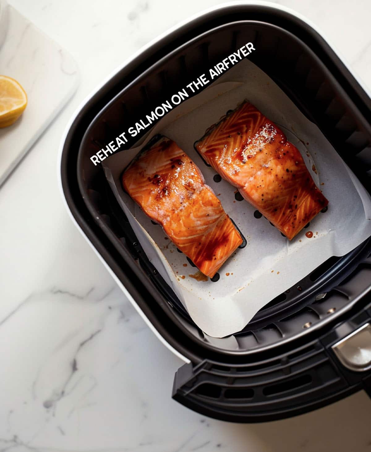Salmon fillet placed in an air fryer basket for reheating.