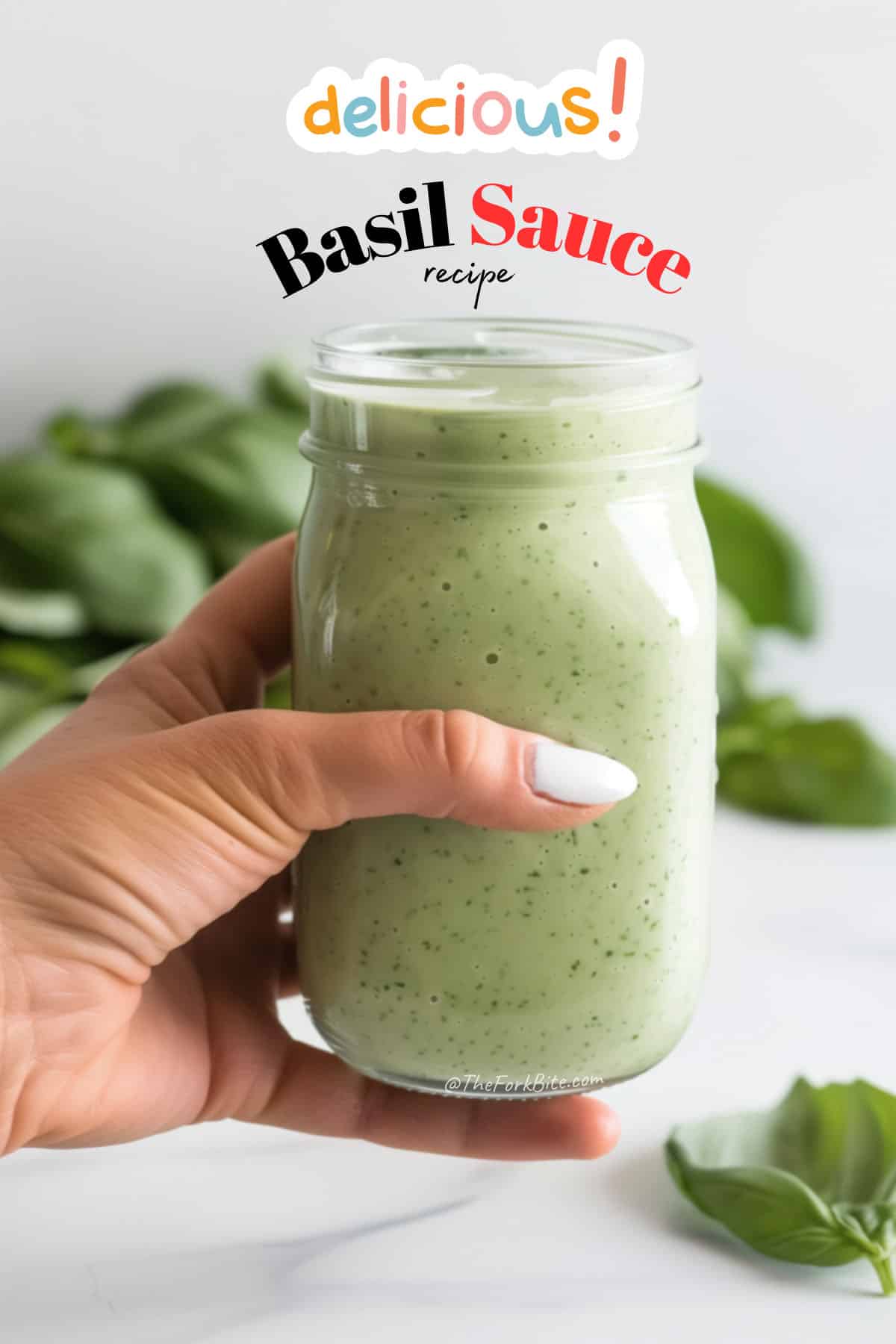 Close-up of a creamy, bright green basil sauce with flecks of herbs, in a mason jar