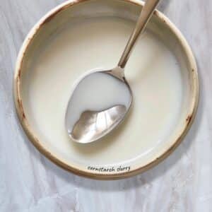 Whisking cornstarch slurry into a bowl for a silky, lump-free finish