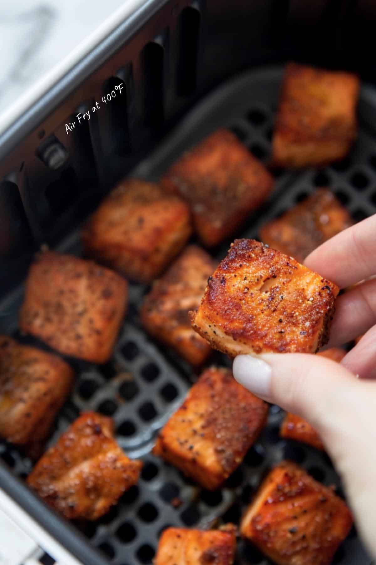 Seasoned salmon cubes placed in the air fryer, ready to transform into crispy, tender bites.
