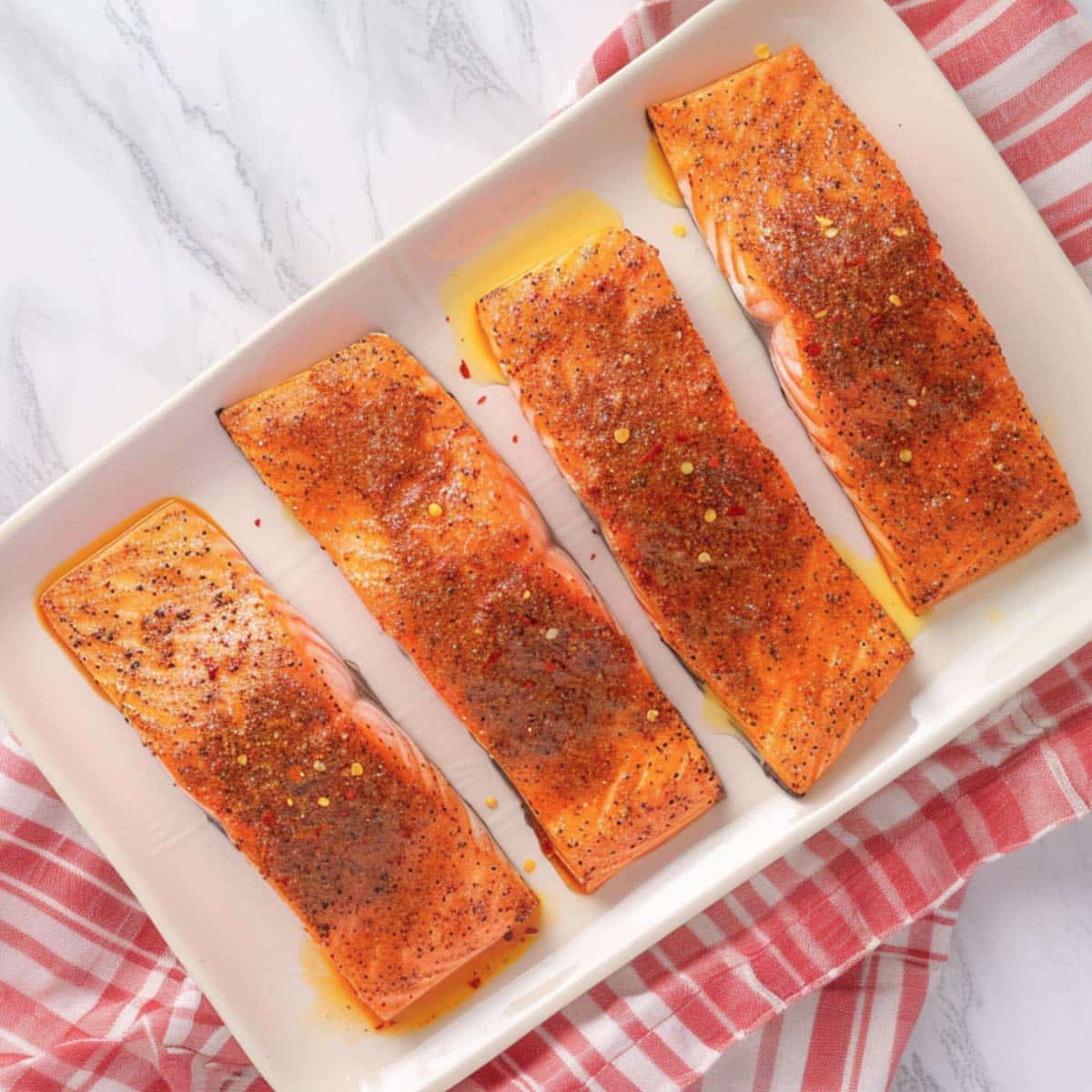 Seasoning salmon fillets with a spice mixture for air fryer salmon tacos.