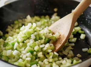 Chopped onions, celery, and bell peppers cooking in a skillet for Shrimp Étouffée.