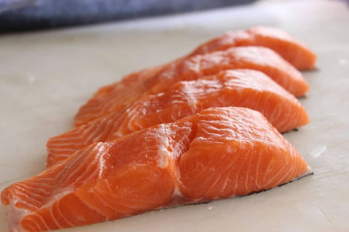 Fresh raw salmon fillets neatly arranged on a cutting board